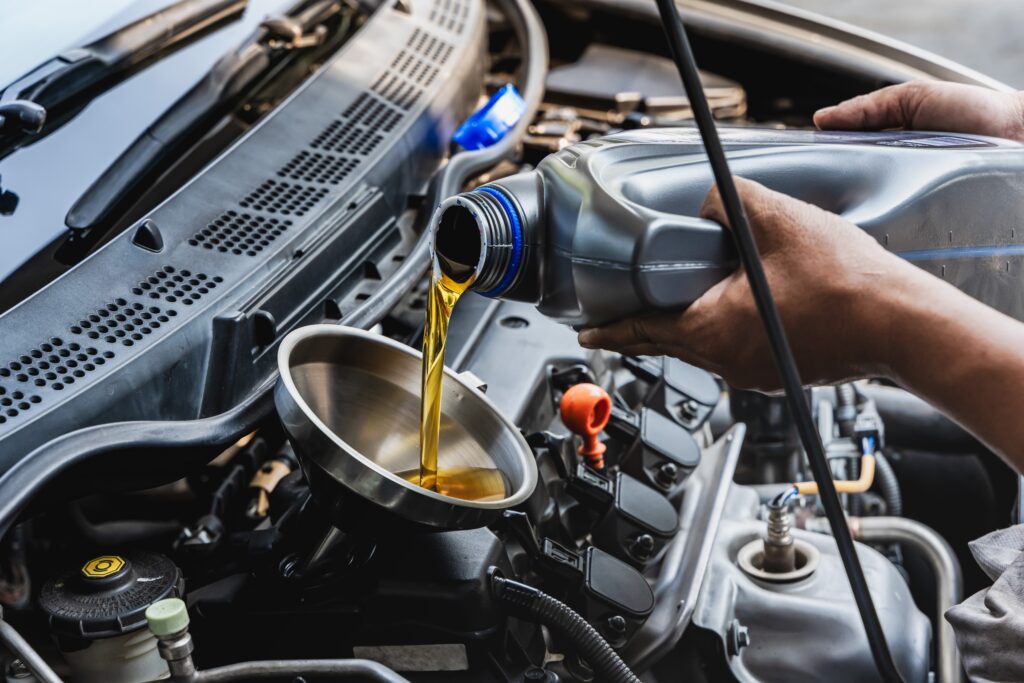 car,mechanic,pouring,engine,oil,into,vehicle,during,doing,car
